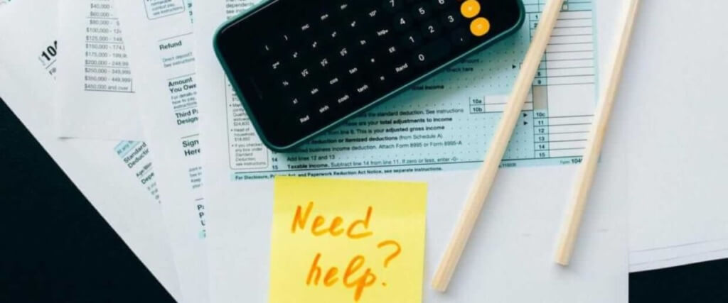 A calculator and a note of need help are present on the auditing sheet